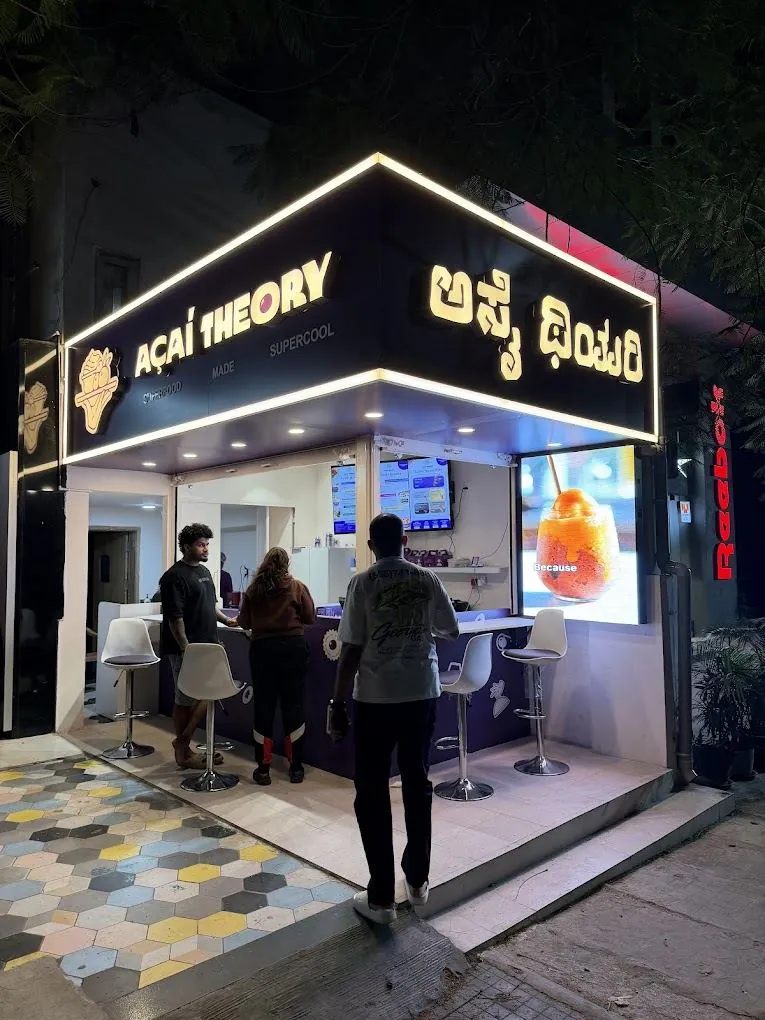 Açaí Theory storefront in Indiranagar at night, with its outdoor LED wall lit beside the counter