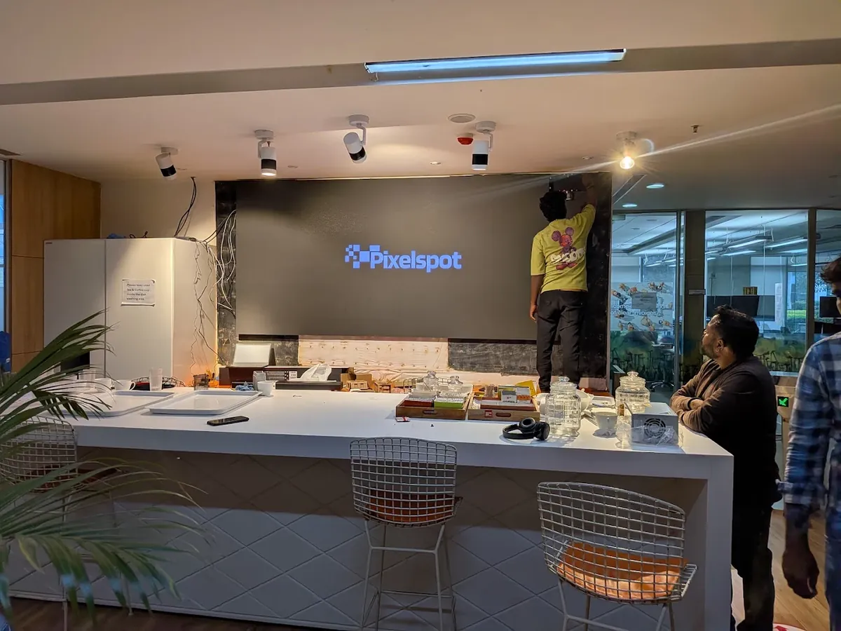 PixelSpot technician working on the face of the indoor LED video wall during installation in a Bengaluru office cafeteria